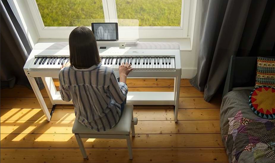 Woman playing Kawai ES520 in bedroom